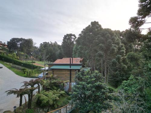 a cabin in the middle of a park with trees at Pousada Canto da Nascente in Monte Verde