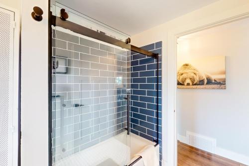 a bathroom with a shower with blue tiles at Sleeping Bear in Empire