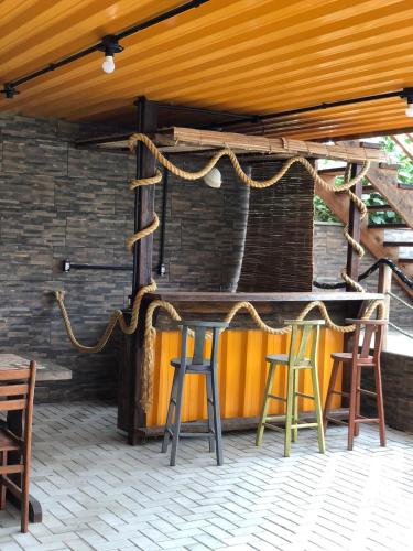 a bar with three stools sitting under a roof at Pousada São Miguel Beach Beira Mar in Penha
