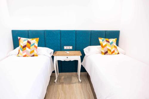 2 camas en una habitación con una mesa entre ellas en Luxury Apartments Sea Sabi con garaje, en Corralejo