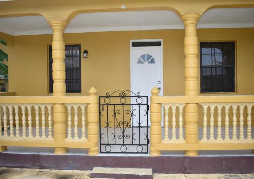 una casa amarilla con una puerta y una puerta blanca en Villa Cherry, en Gros Islet