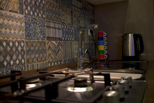 a kitchen with a stove and a sink with tiles at Astrea in Naples