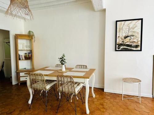 uma sala de jantar com uma mesa de madeira e cadeiras em "Douceur de vignes", cosy, coeur de ville, Classé 3 étoiles - BY PRIMO C0NCIERGERIE em Chalon-sur-Saône