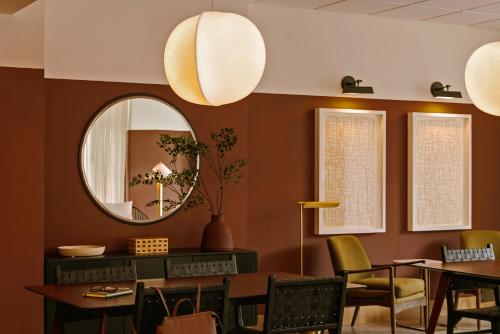 a dining room with a mirror and tables and chairs at Sonder The Fitz in Saint Paul