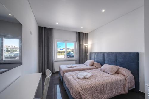 1 dormitorio con 2 camas y ventana en Apartment Paradise Baleal with AC, en Baleal