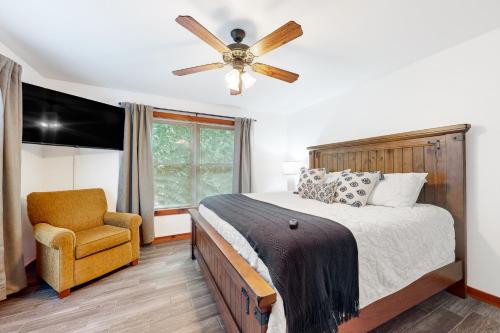 a bedroom with a bed and a chair and a ceiling fan at Firefly Ridge in Townsend
