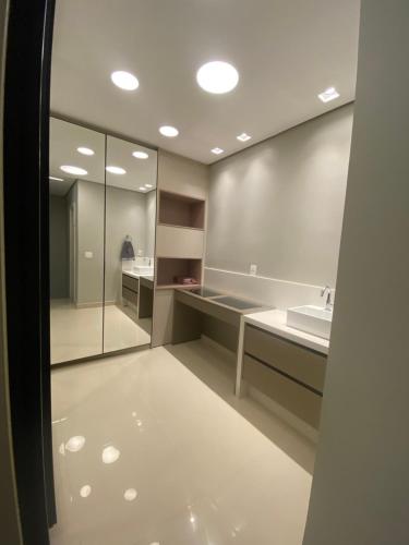 a bathroom with a sink and a mirror at Flat Studio DNA Smart style in Goiânia