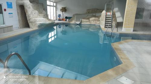 a swimming pool with blue water in a hotel at Oléron Mobil home climatisé tout confort 50 m de l'océan in La Bétaudière