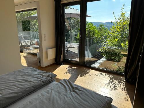 Schlafzimmer mit einer großen Glastür zu einem Balkon in der Unterkunft Ferienhaus Poppenhausen in Poppenhausen