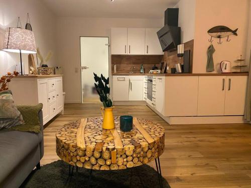 a living room with a table in front of a kitchen at “Heimathafen“ in Bad Zwischenahn in Bad Zwischenahn