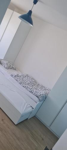 een bed in een witte kamer met een lamp bij Villa Senec Gardens in Senec