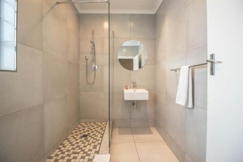 y baño con ducha y lavamanos. en Spring Tide Inn by CTHA, en Ciudad del Cabo