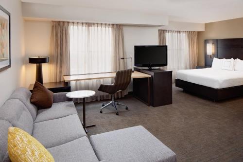 a hotel room with a couch and a bed at Residence Inn Arlington in Arlington