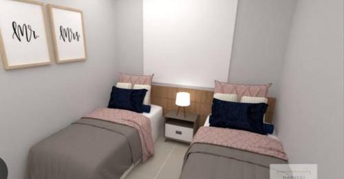 a bedroom with two beds and a table with a lamp at Hostel Adriana Alves in Porto De Galinhas