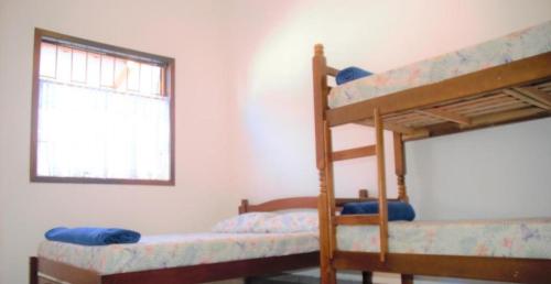 two bunk beds in a room with a window at Hostel Adriana Alves in Porto De Galinhas