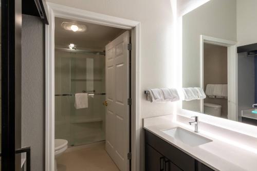 a white bathroom with a sink and a shower at Residence Inn by Marriott Charleston Airport in Charleston