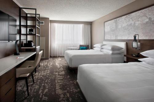 a hotel room with two beds and a desk at Marriott Albany in Albany