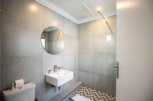 a bathroom with a sink and a mirror at Spring Tide Inn by CTHA in Cape Town
