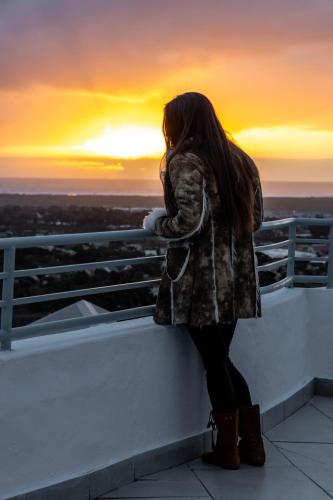 a woman standing on a ledge looking at the sunset at Capri Sands Luxury Guest House in Capri Village