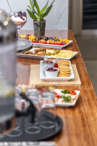a wooden table with plates of food on it at Capri Sands Luxury Guest House in Capri Village