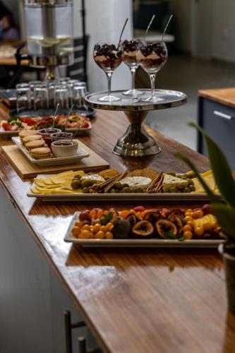a buffet with several plates of food and glasses of wine at Capri Sands Luxury Guest House in Capri Village