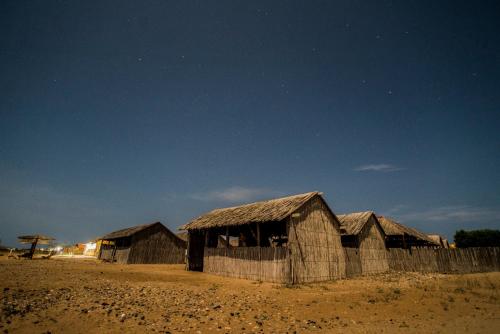 a group of huts in the desert at night at Rancheria Utta in Cabo de la Vela