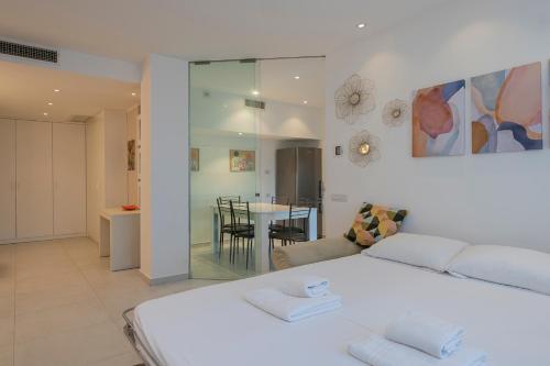 um quarto com uma cama branca e uma sala de jantar em [IHost Apartment] - Tito Livio 20 em Milão