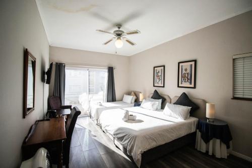 a bedroom with two beds and a ceiling fan at Spring Tide Inn by CTHA in Cape Town
