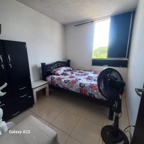a bedroom with a bed and a window at HABITACION EN APARTAMENTO COMPARTIDO - VENTILADOR in Valledupar