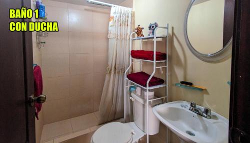 een badkamer met een wastafel, een toilet en een spiegel bij Freddy Departamento amoblado in Cuenca