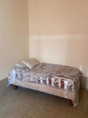 a small bed in a corner of a room at Carlos Espinoza Larrea , Atras de Agua pen in Salinas