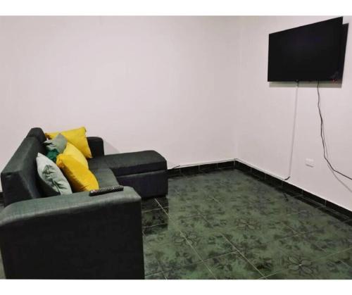 a living room with a couch and a flat screen tv at Pura Vida House in Quepos