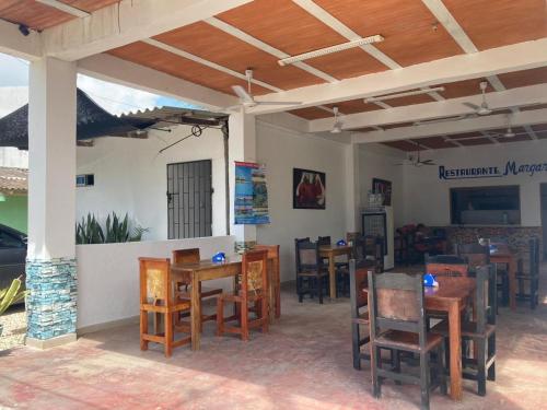 a restaurant with tables and chairs in a room at Habitaciones Mónaco in Coveñas