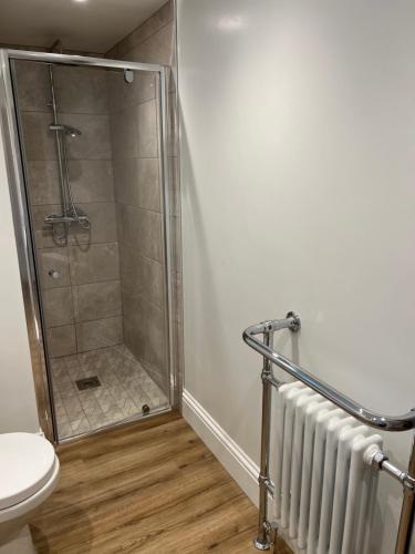 a shower stall in a bathroom with a toilet at The Old Gatehouse Luxury Cottage in Legbourne