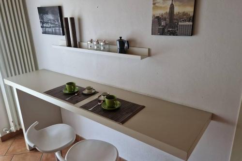 a table with two cups and two chairs on it at Urban Oasis Appartamento vicinanze Como 15km in Cantù