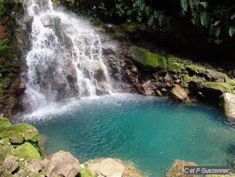 a pool of water in front of a waterfall at VILLA CREOLE in Gourbeyre
