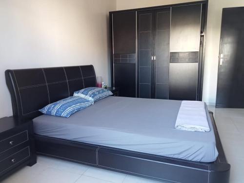 Schlafzimmer mit einem Bett mit einem schwarzen Kopfteil in der Unterkunft Maison indépendante 100m2 à Témara centre in Temara