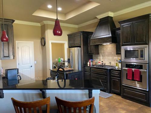 cocina con armarios de madera y encimera negra en Field Stone en Oklahoma City