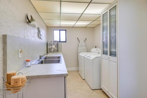 eine Küche mit einer Spüle und einer Waschmaschine in der Unterkunft Canalfront Cape Coral Home with Pool and Dock! in Cape Coral