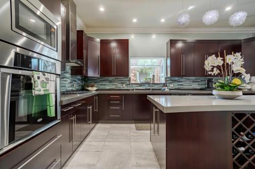a large kitchen with wooden cabinets and a large appliance at Regal 4 bed with hot tub close to Universal sleeps 15 in Los Angeles