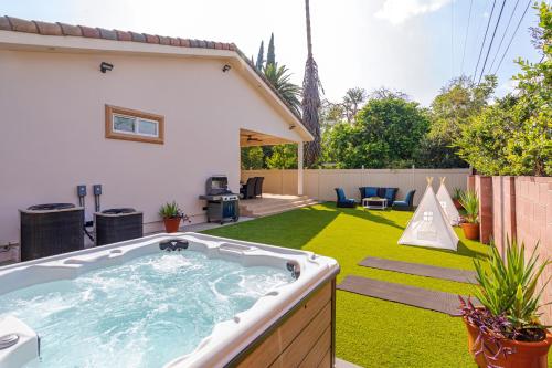 a backyard with a hot tub on a lawn at Regal 4 bed with hot tub close to Universal sleeps 15 in Los Angeles