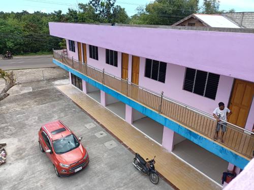 um carro vermelho estacionado na varanda de um edifício em ABEJJEE Motel em Panglao