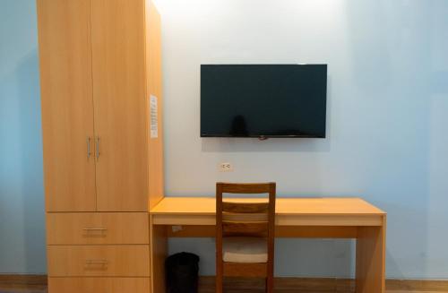 a desk with a chair and a television on a wall at Hotel Laguna Azul in Sauce