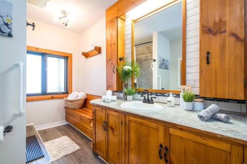 a bathroom with a sink and a mirror at Sundance of Blantyre Lodge w Hot Tub & Sauna House in Walter's Falls