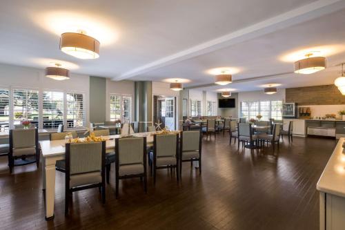una sala da pranzo con tavoli, sedie e finestre di Best Western Sea Island Inn a Beaufort