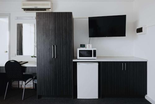 a room with a counter with a microwave and a table at Comfort Inn Traralgon in Traralgon