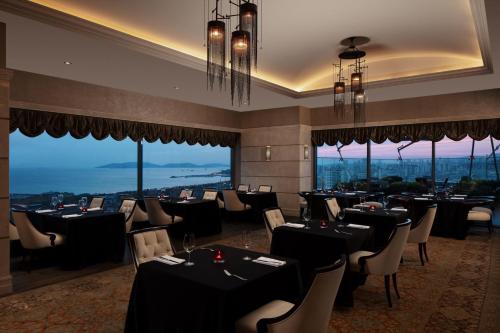 a restaurant with black tables and chairs and windows at Istanbul Marriott Hotel Pendik in Istanbul