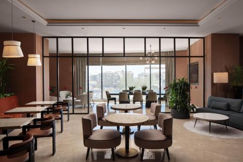 a lobby with tables and chairs and a large window at Istanbul Marriott Hotel Pendik in Istanbul