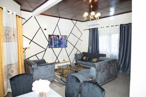 a living room with two couches and a tv at Hypo Guest Lounge in Yaoundé