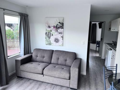 un soggiorno con divano e un dipinto sul muro di Baycourt Lakefront Motel a Taupo